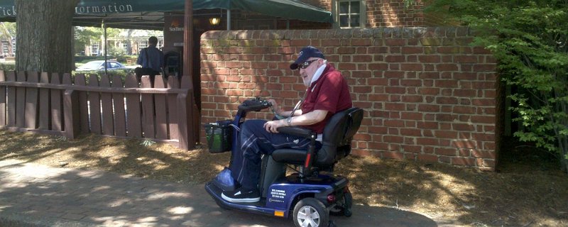 A paralyzed man riding an electrical scooter